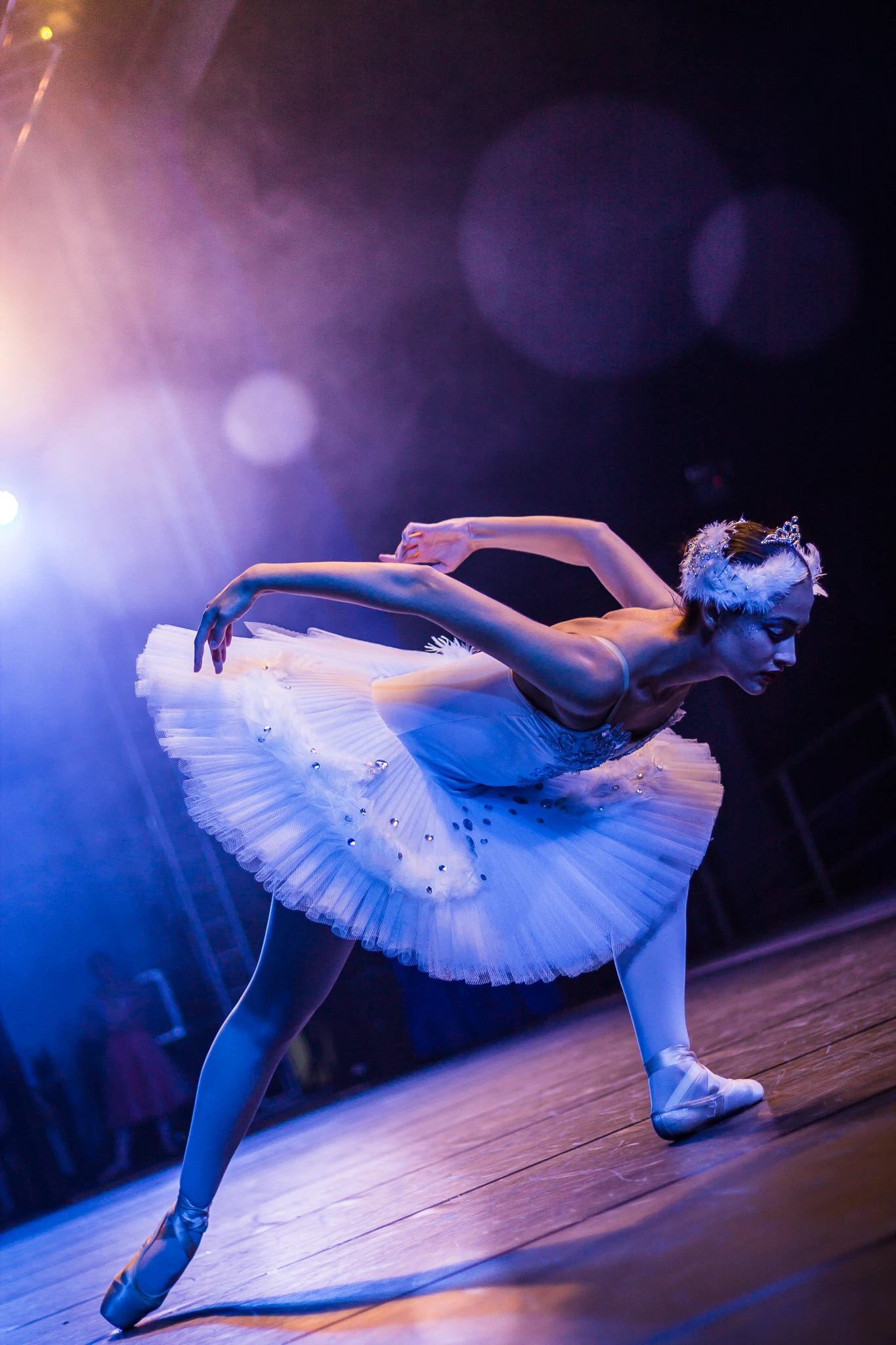 Bailarina em movimento sob luz azul de palco